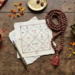 लकड़ी की मेज पर कुंडली चार्ट, रुद्राक्ष माला, दीपक और कुमकुम