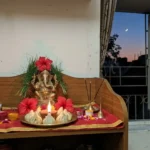 संकष्टी चतुर्थी sankashti chaturthi का महत्व और पूजन विधि घर के मंदिर में गणेश जी की प्रतिमा, मोदक और दीपक, खिड़की से दिखता चाँद